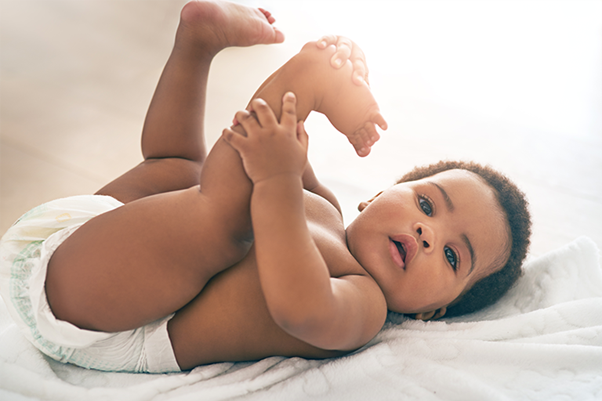 Baby wearing Huggies newborn nappies lying on mum